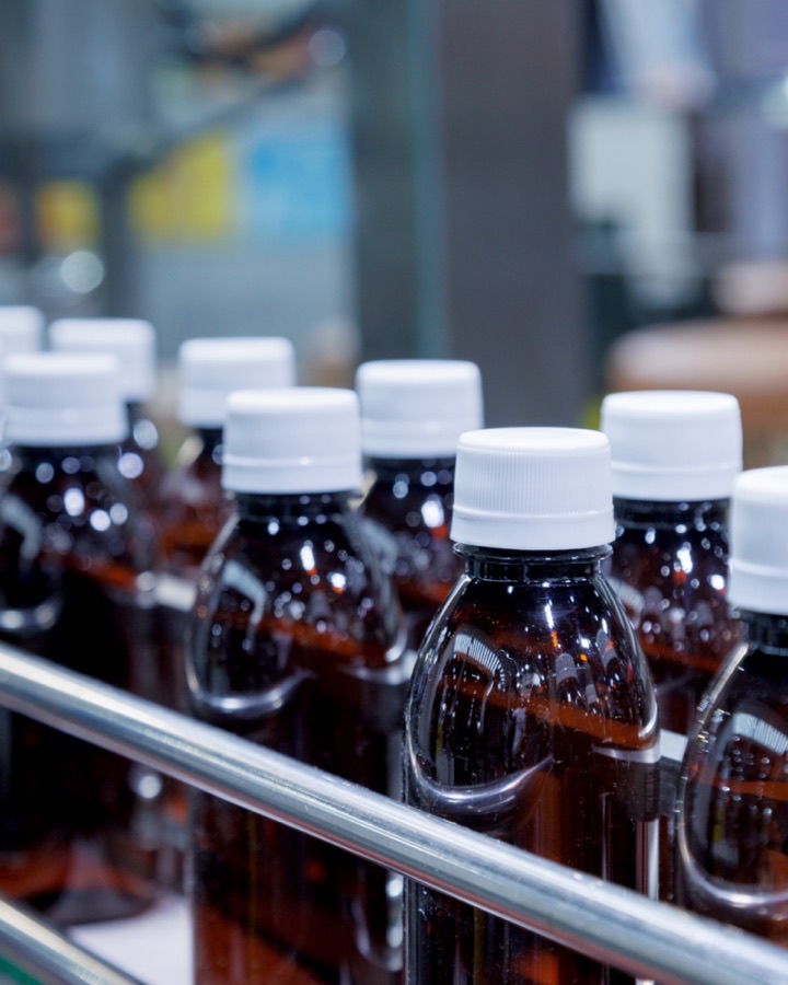 Amber liquid supplement bottles on a production line